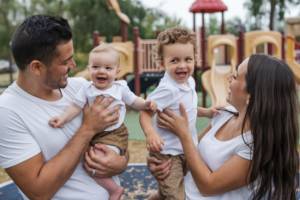 A positive co-parenting family dynamic with happy children in a park