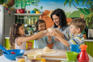 A colorful and playful family kitchen scene with a mother and children cooking together.