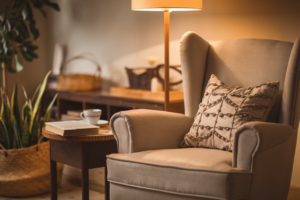 A cozy room with a comfortable armchair, a cup of tea, and a book, symbolizing relaxation and me-time for mothers.